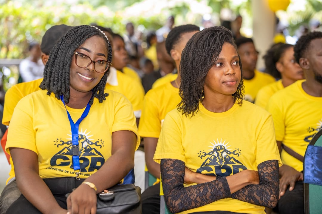 Deux jeunes membres de la GRR en t-shirt jaune du mouvement, assises lors d'une rencontre citoyenne.